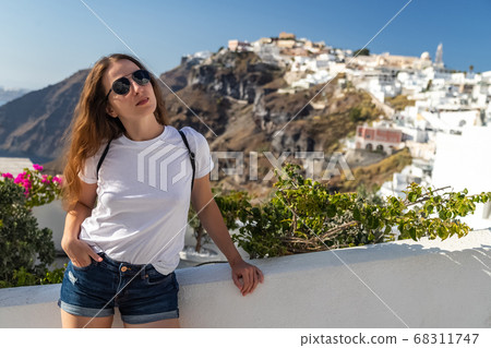 Happy smiling woman tourist traveling on luxury cruise in Mediterranean, Greece, Santorini. Background architecture island sea sky 68311747