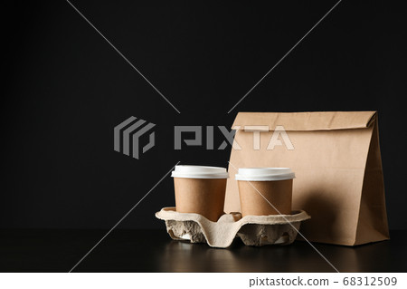 Eco - friendly package and coffee cups on black Eco - friendly package and coffee cups on black 68312509