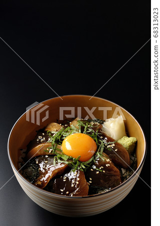 Pickled bowl of bonito with chopped seaweed, large leaves, gari, wasabi and egg yolk on the center (black background) Pickled bowl of bonito with chopped seaweed, large leaves, gari, wasabi and egg yolk on the center (black background) 68313023