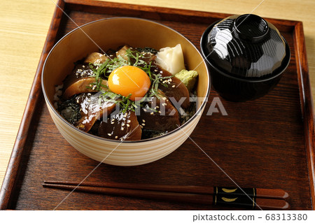 Pickled bonito rice bowl with chopped seaweed, large leaves, gari, wasabi and egg yolk on the center and soup Pickled bonito rice bowl with chopped seaweed, large leaves, gari, wasabi and egg yolk on the center and soup 68313380