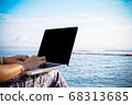 Business woman uses a laptop computer to work at the sea 68313685