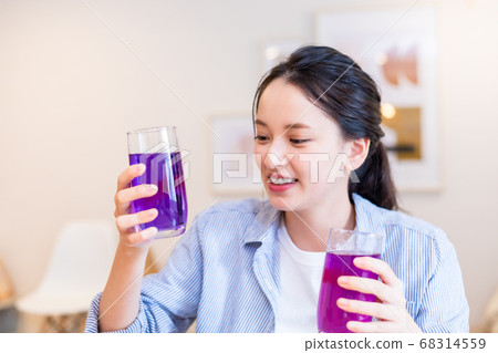 女人享受蝴蝶豌豆的顏色變化 女人享受蝴蝶豌豆的顏色變化 68314559
