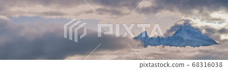 Foggy clouds, mountain top and sun glow in evening 68316038
