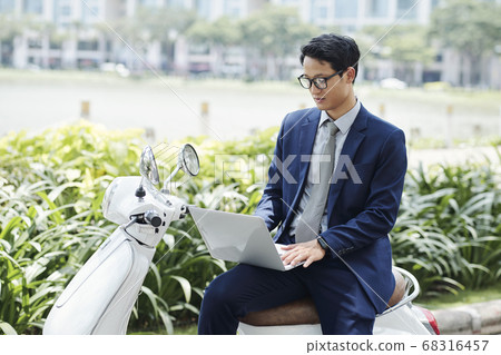 Entrepreneur working on laptop outdoors Entrepreneur working on laptop outdoors 68316457