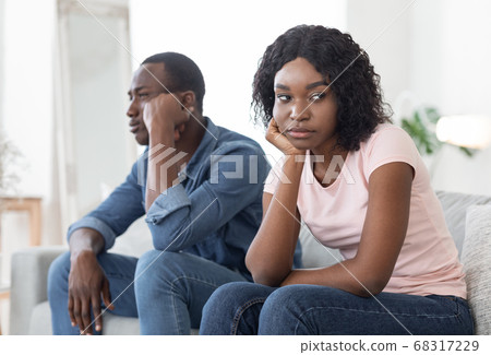 Frustrated african man and woman sitting on couch at home 68317229