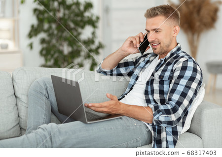 Portrait of successful smiling businessman using phone and pc Portrait of successful smiling businessman using phone and pc 68317403