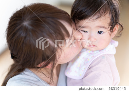 Young mom kissing baby's cheek 68319443