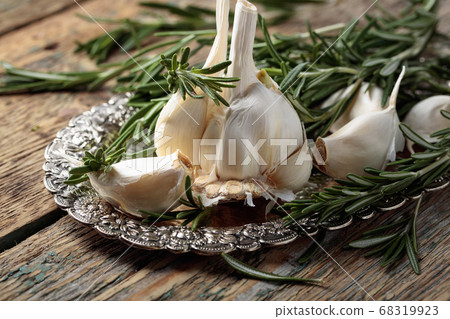 Rosemary and garlic on a wooden table. Rosemary and garlic on a wooden table. 68319923