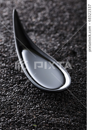 Sesame oil in small bowl on a background of black Sesame oil in small bowl on a background of black 68321537