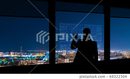 The The businessman working on a virtual screen on the wind turbines background working on a virtual screen on the night cityscape background 68322304