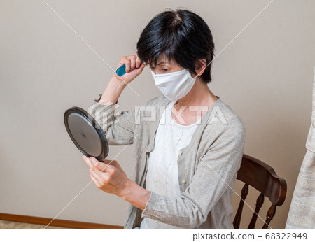 戴著面具的中年婦女看手鏡 戴著面具的中年婦女看手鏡 68322949
