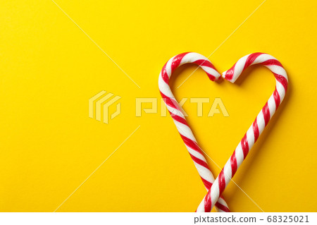 Sweet candy canes on yellow background, space for 68325021