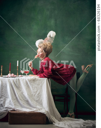 Young woman as Marie Antoinette on dark background. Retro style, comparison of eras concept. Young woman as Marie Antoinette on dark background. Retro style, comparison of eras concept. 68326194