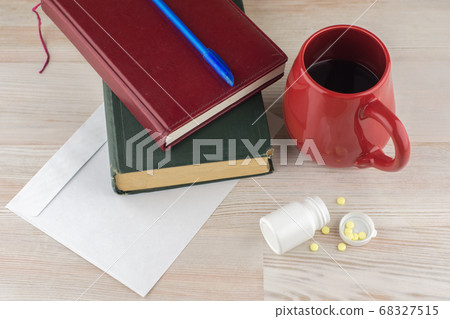 ensuring good employee: a pack of tablets of ephedrine, Cup of strong coffee. nearby are the envelope, a book, Notepad and blue pen, top view ensuring good employee: a pack of tablets of ephedrine, Cup of strong coffee. nearby are the envelope, a book, Notepad and blue pen, top view 68327515