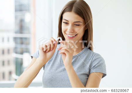 Stop smoking, a young woman holding a broken cigarette 68328067