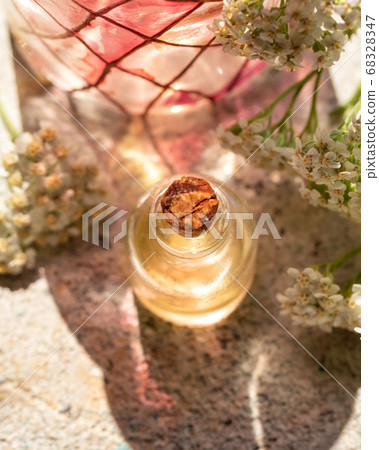 A bottle of essential oil with blooming yarrow A bottle of essential oil with blooming yarrow 68328347