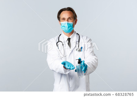 Covid-19, preventing virus, healthcare workers and vaccination concept. Doctor in medical mask and gloves explain important of hygiene, using hand sanitizer during coronavirus outbreak 68328765