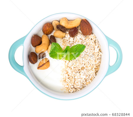 Healthy breakfast. Bowl of yogurt with almond, muesli, mint isolated on white. 68328844