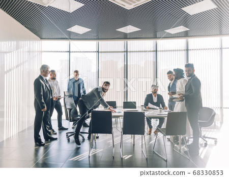 Multiracial partners dispute at negotiations, having fun while settling conflict Multiracial partners dispute at negotiations, having fun while settling conflict 68330853