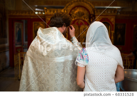 Orthodox Christian priest and parishioner praying in the church. Orthodox Christian priest and parishioner praying in the church. 68331528