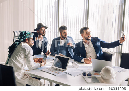 Caucasian businessman taking selfie with his middle eastern and indian partners Caucasian businessman taking selfie with his middle eastern and indian partners 68331608
