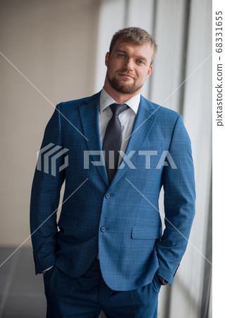 confident fair-haired CEO with blue beautiful eyes looking at the camera 68331655
