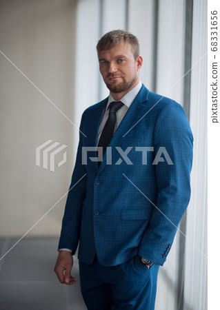 close up portrait of a young businessman standing with his hand in the pocket 68331656
