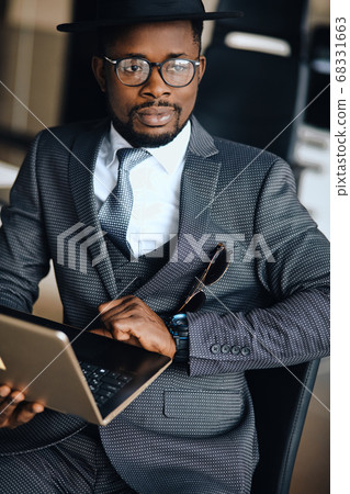 succesful businesman with laptop posing to the camera succesful businesman with laptop posing to the camera 68331663