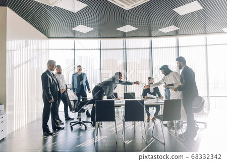 Multiracial partners dispute at negotiations, having fun while settling conflict Multiracial partners dispute at negotiations, having fun while settling conflict 68332342