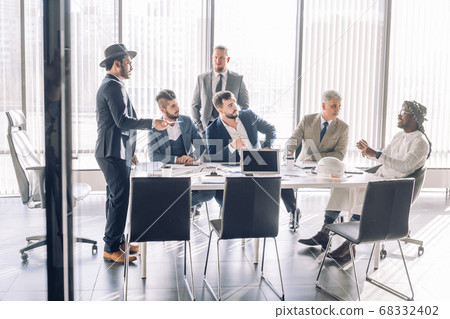 Serious Indian CEO in interacting with multiracial vendors at corporate meeting Serious Indian CEO in interacting with multiracial vendors at corporate meeting 68332402