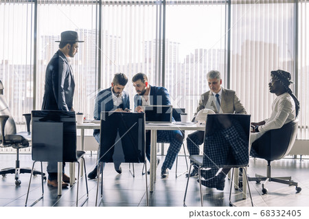 Serious Indian CEO in interacting with multiracial vendors at corporate meeting Serious Indian CEO in interacting with multiracial vendors at corporate meeting 68332405