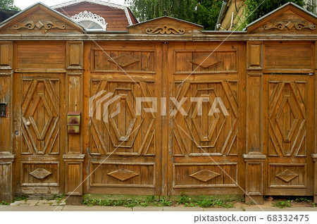 An old wooden fence with carved decorations. Russian village.A well-to-do house. An old wooden fence with carved decorations. Russian village.A well-to-do house. 68332475