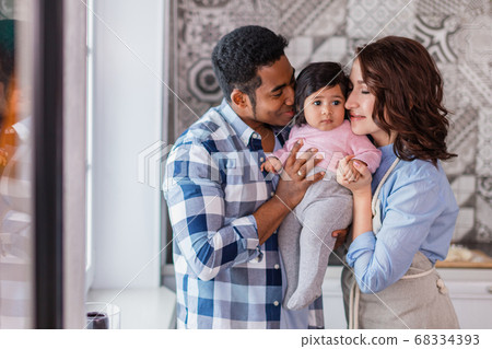 mother and father embracing their kid mother and father embracing their kid 68334393