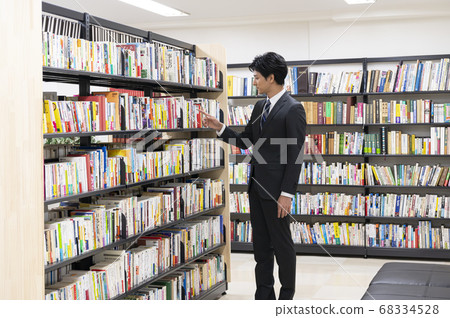 年輕人在圖書館裡找書 年輕人在圖書館裡找書 68334528