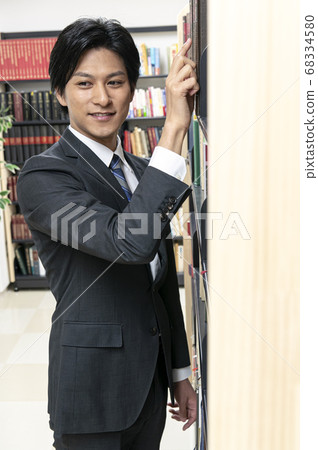 年輕人在圖書館裡找書 年輕人在圖書館裡找書 68334580