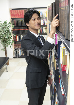 年輕人在圖書館裡找書 68334582