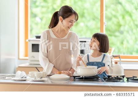 Mom and girl cooking in the kitchen 68335571