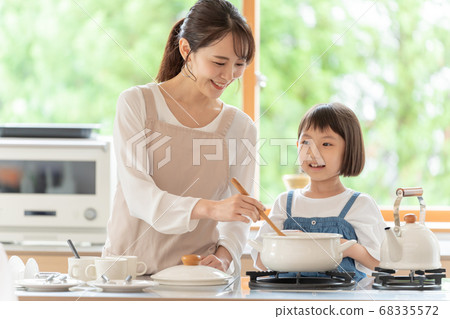 Mom and girl cooking in the kitchen 68335572