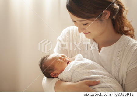 Mother holding a newborn baby Mother holding a newborn baby 68336912
