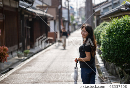 雨後,一名婦女在奈良縣濱原市今井町用雨傘走遍全市 雨後,一名婦女在奈良縣濱原市今井町用雨傘走遍全市 68337508