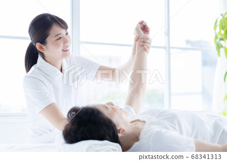 Medical senior woman doing gymnastics with physical therapist 68341313