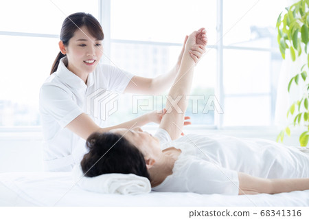 Medical senior woman doing gymnastics with physical therapist 68341316