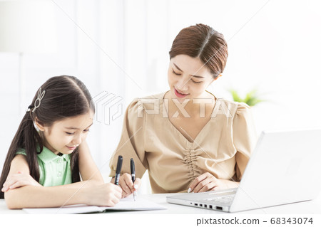 Mother is working and teaching her daughter doing Mother is working and teaching her daughter doing 68343074