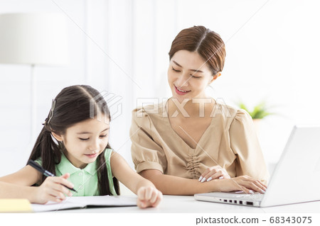Mother is working and teaching her daughter doing Mother is working and teaching her daughter doing 68343075
