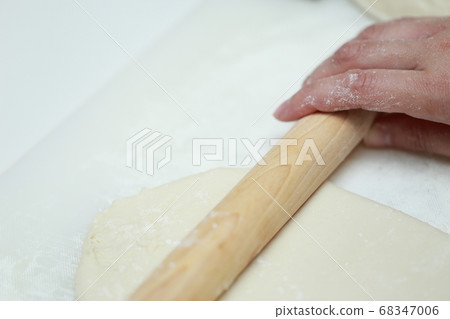 Housewife stretching handmade bread dough with a cotton swab Housewife stretching handmade bread dough with a cotton swab 68347006