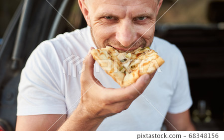 Close-up view of happy man eating pizza Close-up view of happy man eating pizza 68348156