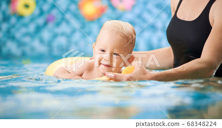 Mother with baby boy in swimming pool training Mother with baby boy in swimming pool training 68348224