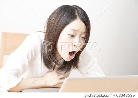 Female watching a movie on a laptop Female watching a movie on a laptop 68348559