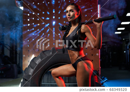 Female bodybuilder posing with sledgehammer on shoulders. Female bodybuilder posing with sledgehammer on shoulders. 68349320