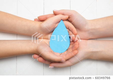Human hands holding water drop isolated on white wooden background Human hands holding water drop isolated on white wooden background 68349766